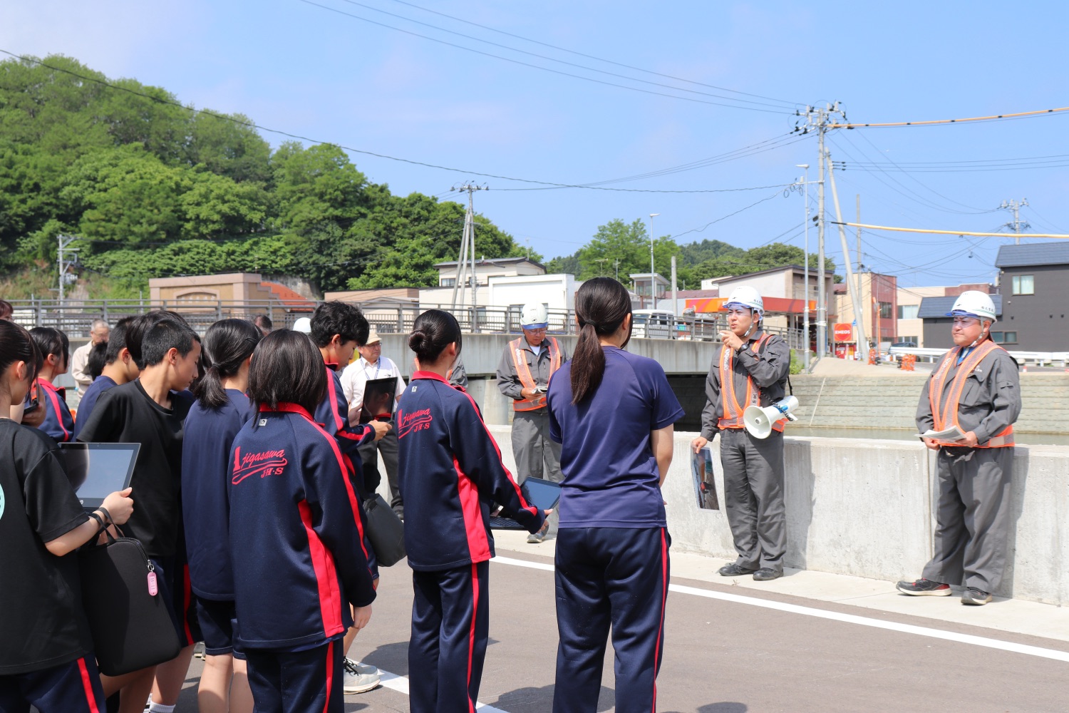 地元の中学生と災害対策工事の現場見学を行う冨田あきしげ（2025年）